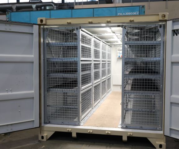 20ft container outfitted with SHARKCAGEs — mobile cages with shelves.